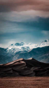 Montagnes enneigées sous un ciel dramatique