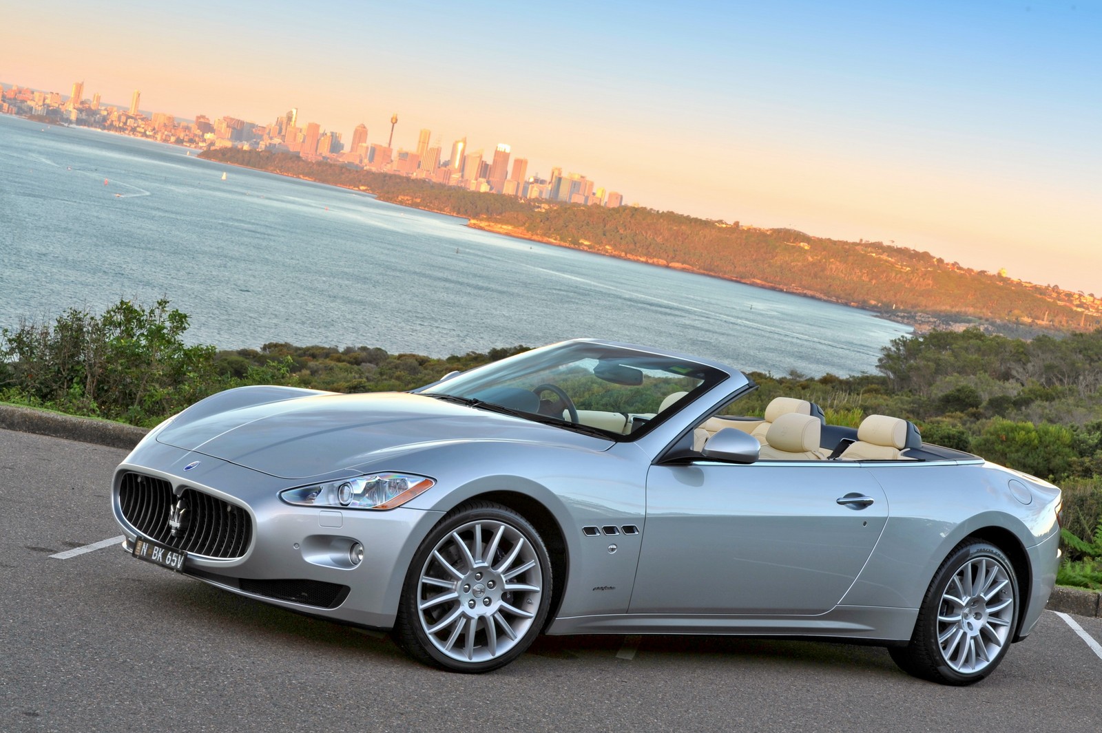 Um maserati prateado estacionado em um estacionamento ao lado do oceano (maserati, carro, carro esportivo, supercarro, maserati granturismo)