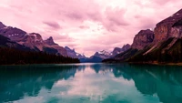 Lago tranquilo rodeado de majestuosas montañas al anochecer