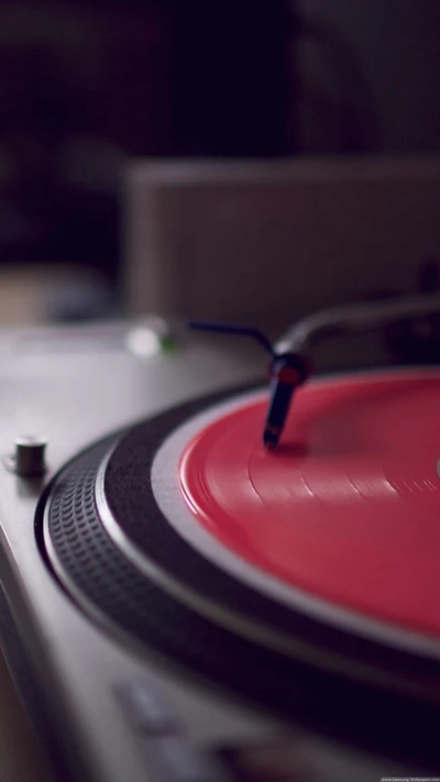 Nahaufnahme eines Plattenspielers mit einer roten Vinylplatte