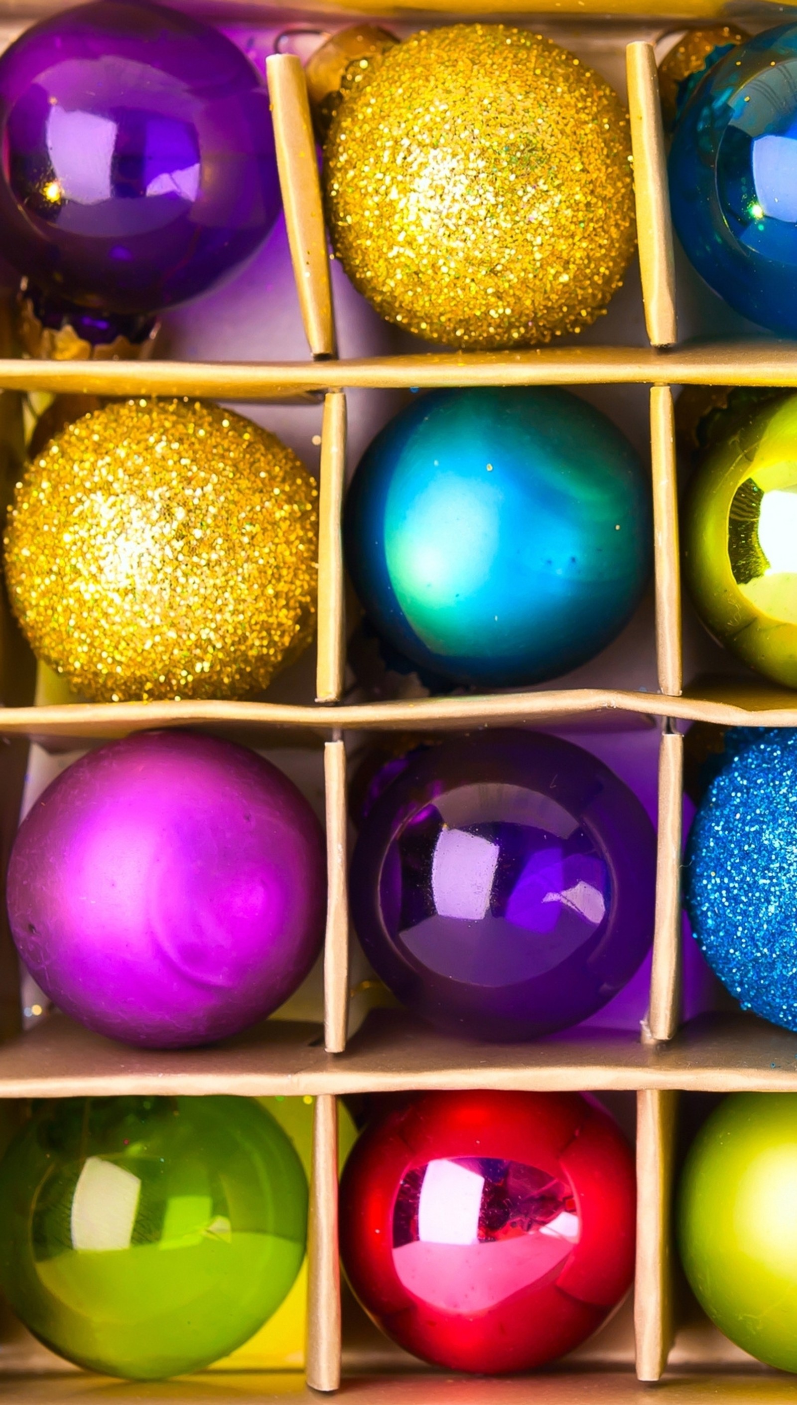 A close up of a box of brightly colored christmas ornaments (christmas balls, holiday)