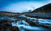 Frühe Morgenruhe am Mount Hood: Ein ruhiger Bach fließt durch felsiges Gelände unter einem schneebedeckten Gipfel