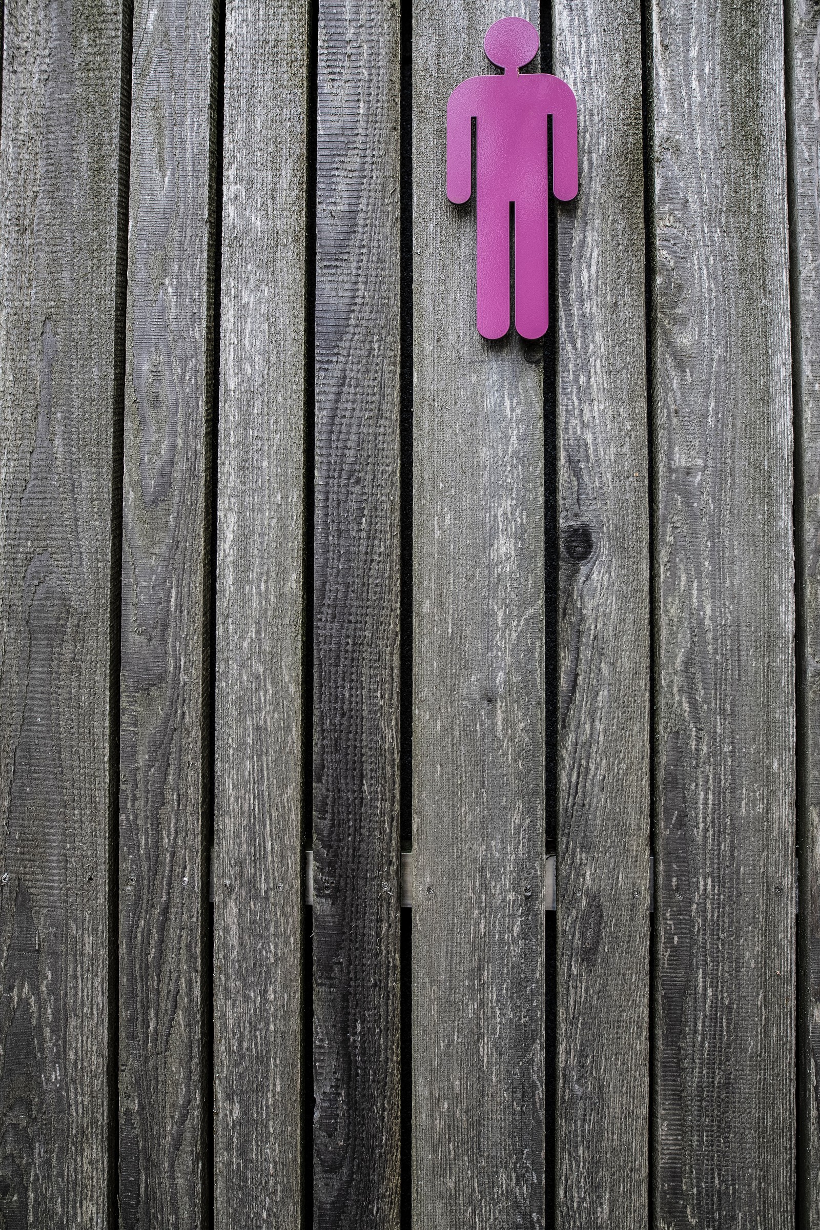 Hay un letrero rosa en una cerca de madera que dice hombres (madera, rosa, rojo, línea, madera dura)