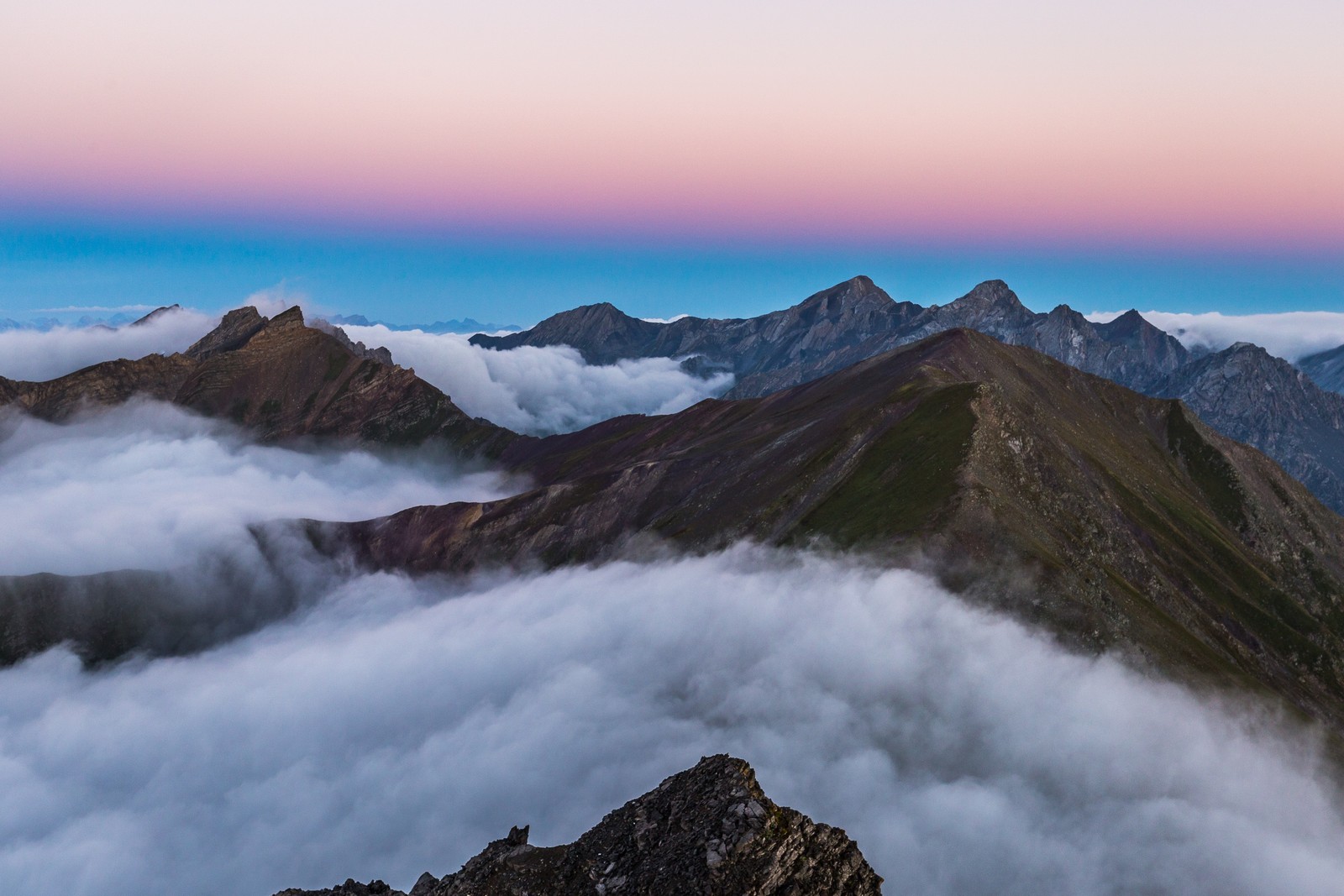 Une vue d'une chaîne de montagnes avec quelques nuages dans l'air (chaîne de montagnes, lever de soleil, sommets de montagne, davos, suisse)