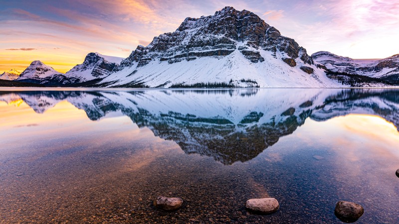 Гора с озером и камнями на переднем плане (озеро боу, bow lake, crowfoot mountain, канада, национальный парк банфф)