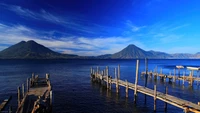 Muelle de madera tranquilo contra majestuosas montañas y cielo despejado