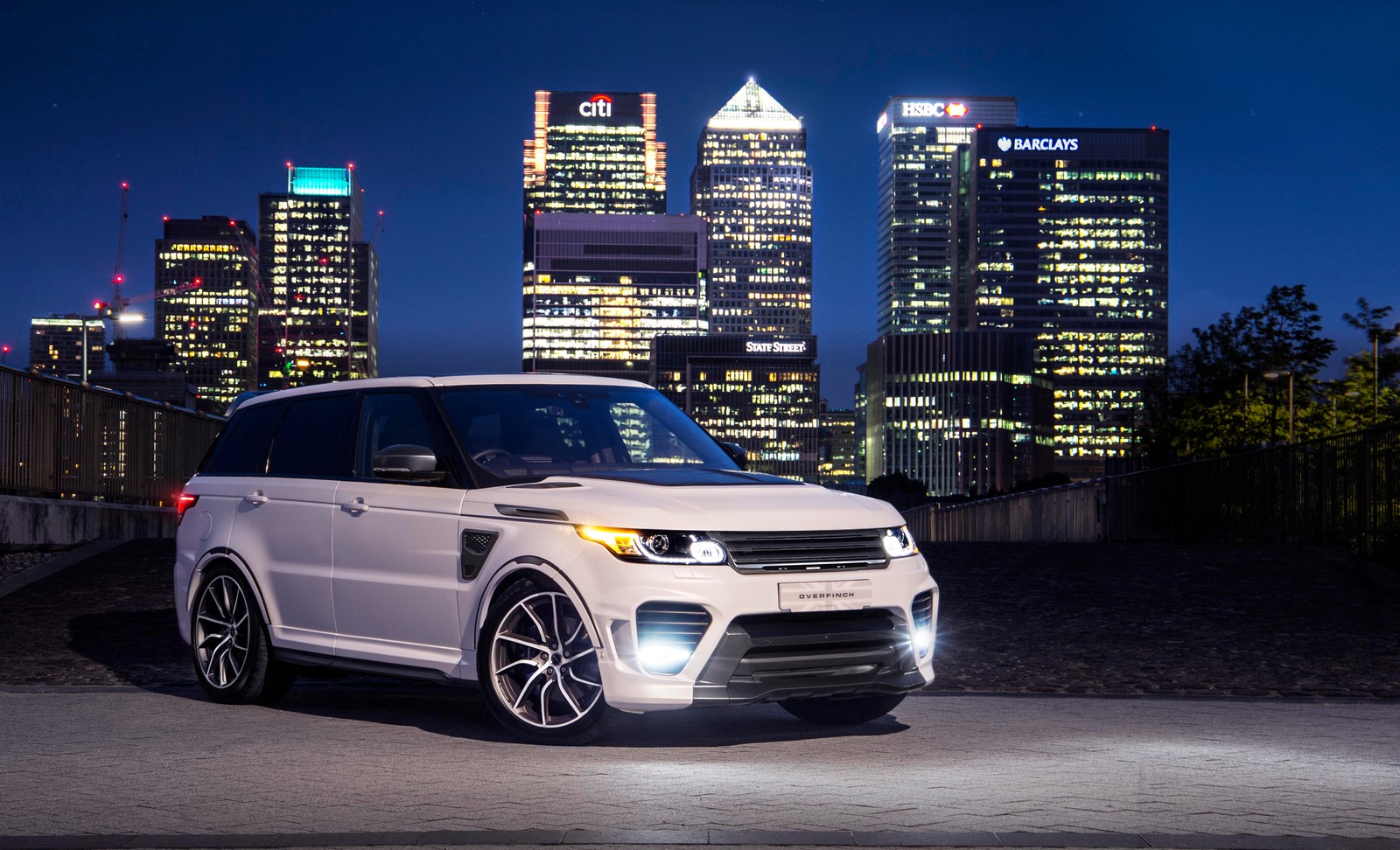 A white range rover parked in front of a city skyline (land rover range rover sport svr, overfinch supersport, 2020, 5k, cars)