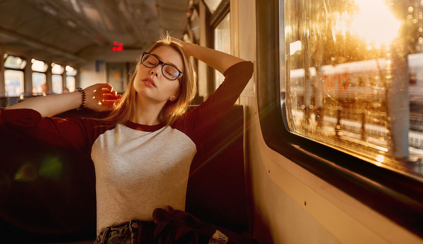 Femme floue assise dans un train regardant par la fenêtre (lunettes, lunettes de soleil, cheveux, rouge, beauté)