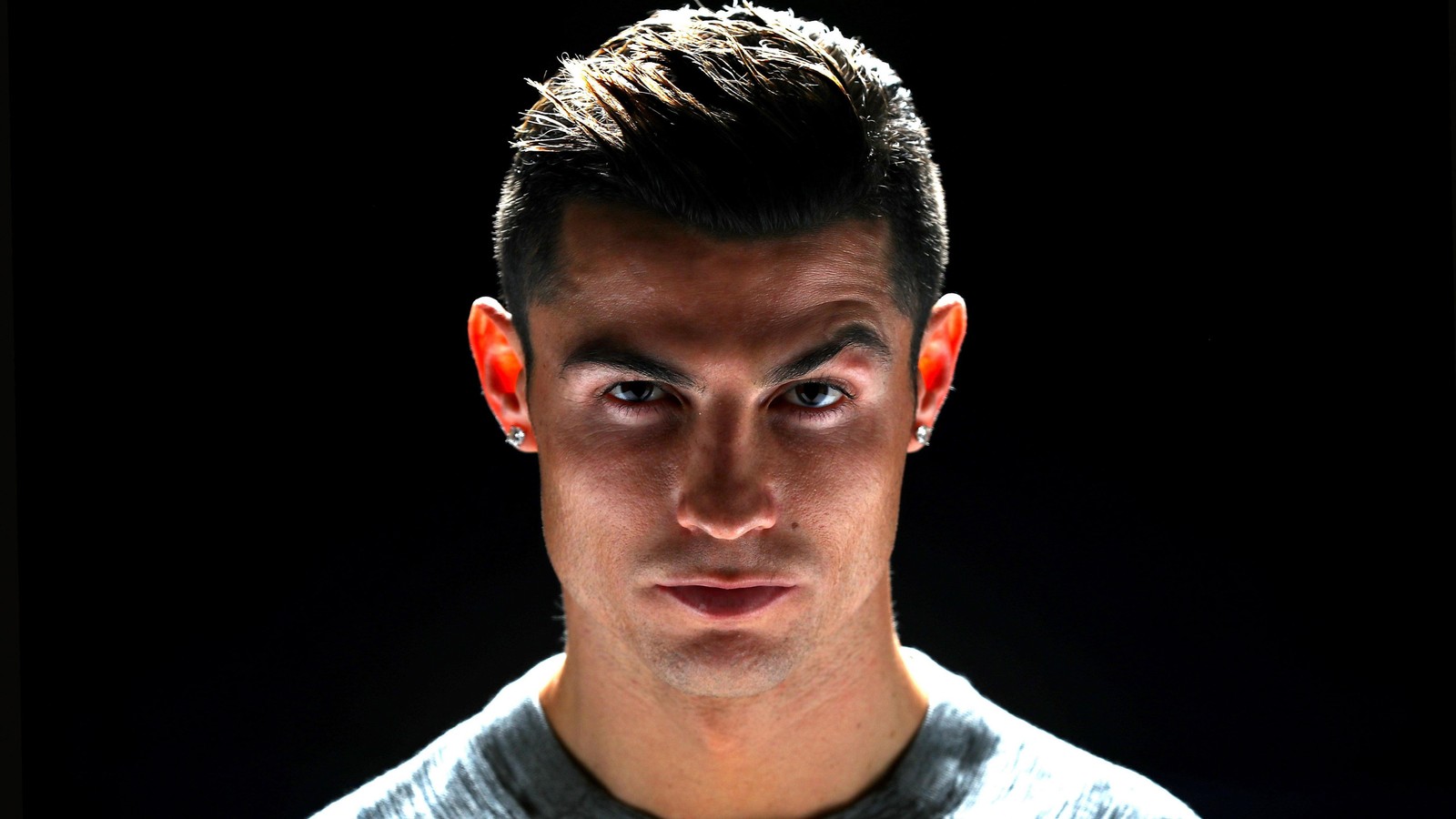 Arafed man with a piercing on his ear and a black background (cristiano ronaldo, face, amoled, 5k, black background)