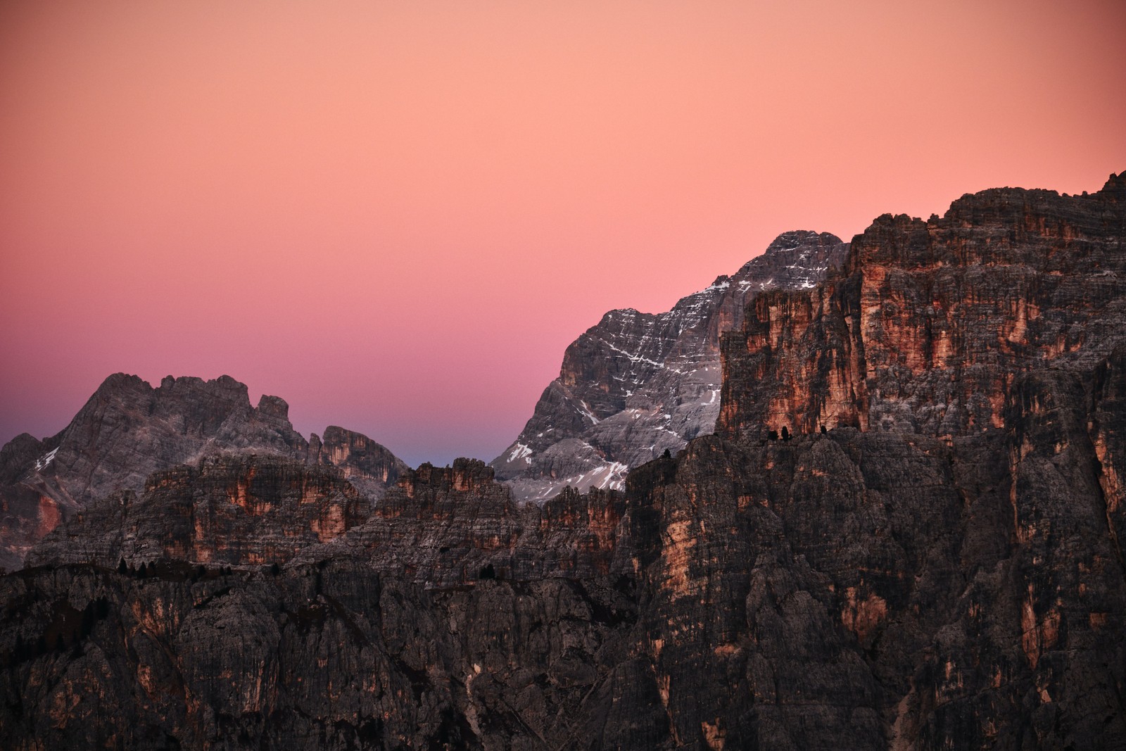 Uma imagem editada de uma cadeia de montanhas com um céu rosa (passo giau, montanhas, dolomitas, dolomites, por do sol)