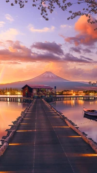 Pôr do sol sereno sobre o lago da montanha com píer e cabana