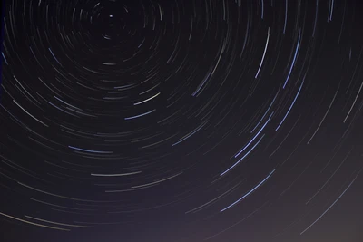 Traînées d'étoiles dans un ciel noir : Une danse astronomique