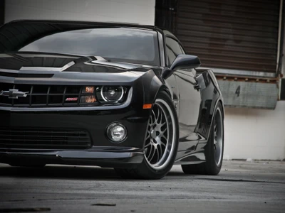 Chevrolet Camaro preto elegante com rodas personalizadas e postura agressiva