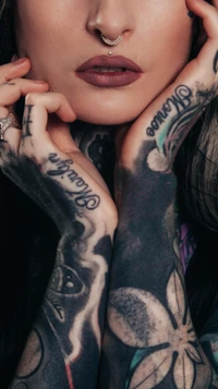 Black and white floral tattooed woman with hands on face