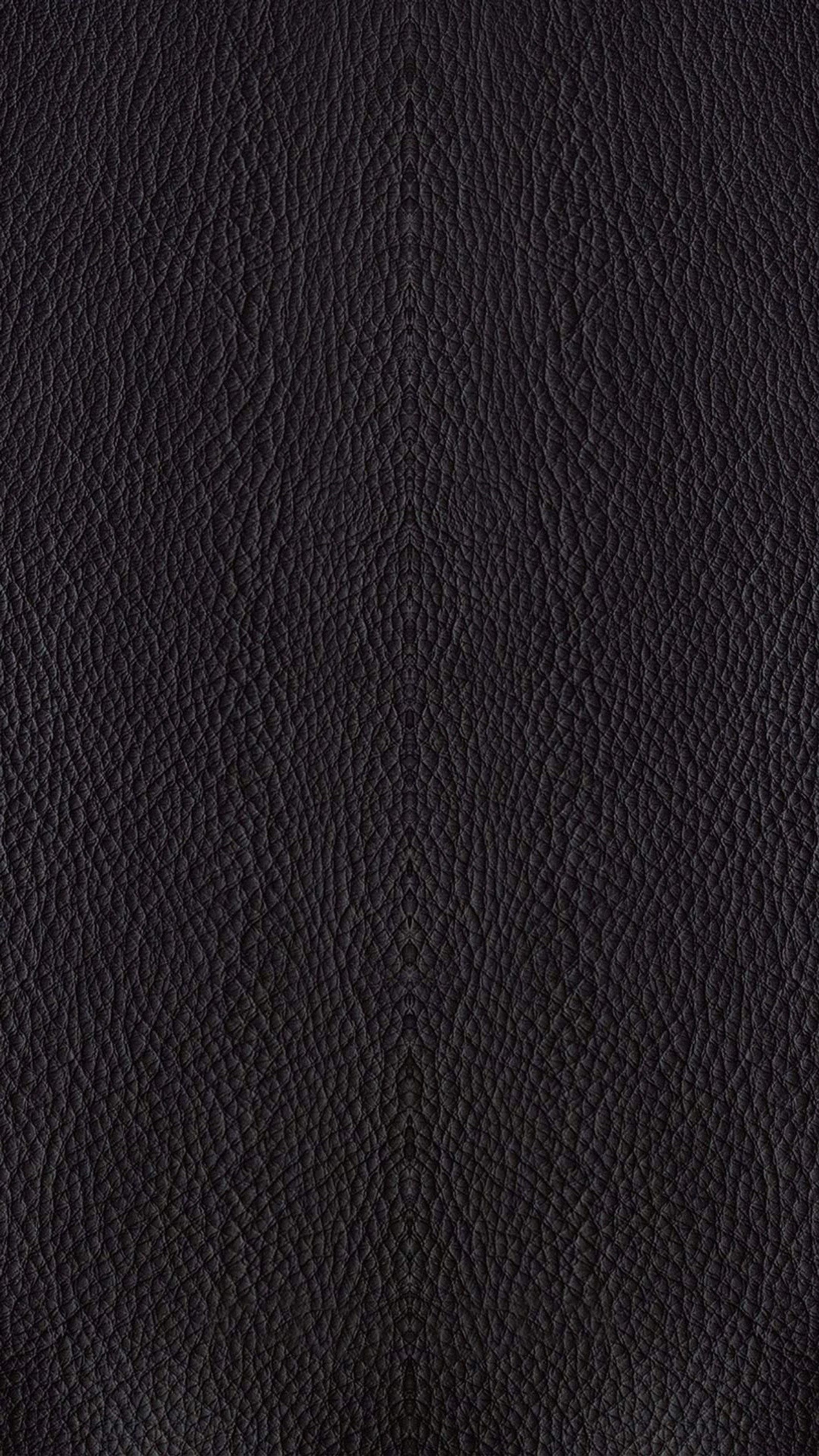 A close up of a black leather surface with a small amount of grain (black, leather, pitch black)