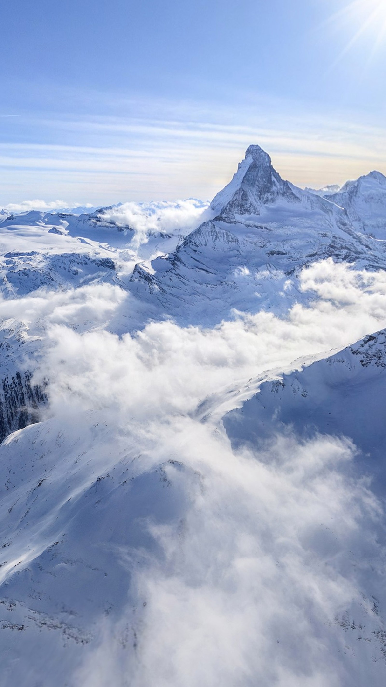 Esquiadores estão em pé no topo de uma montanha com vista para a neve (azul, nuvens, montanhas, tímido, neve)