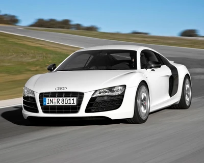 Sleek Audi R8 in dynamic motion on a winding race track.