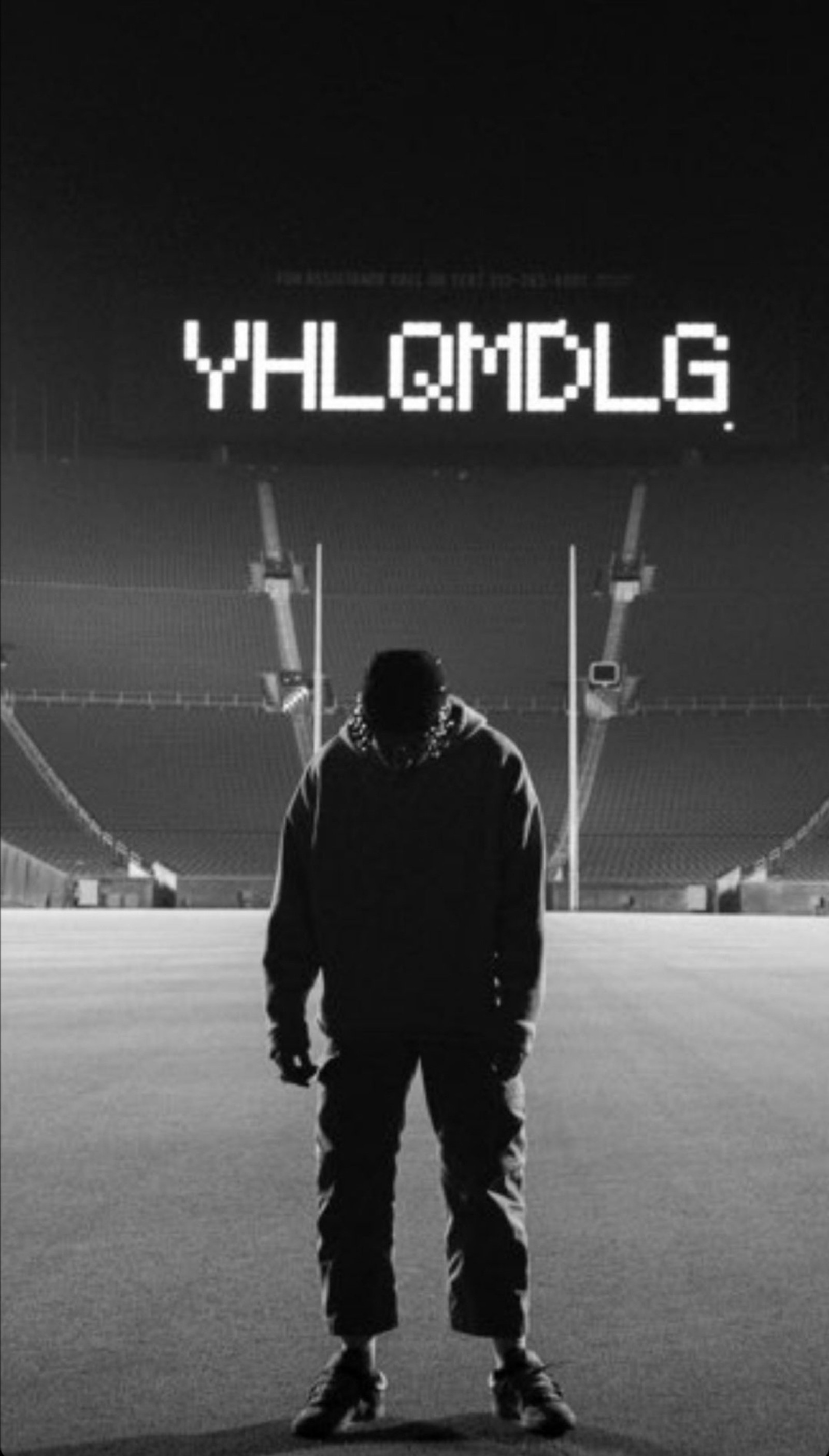 Um homem em pé na frente de um estádio com uma placa que diz yyclmog (bad bunny, yhlqmdlg)