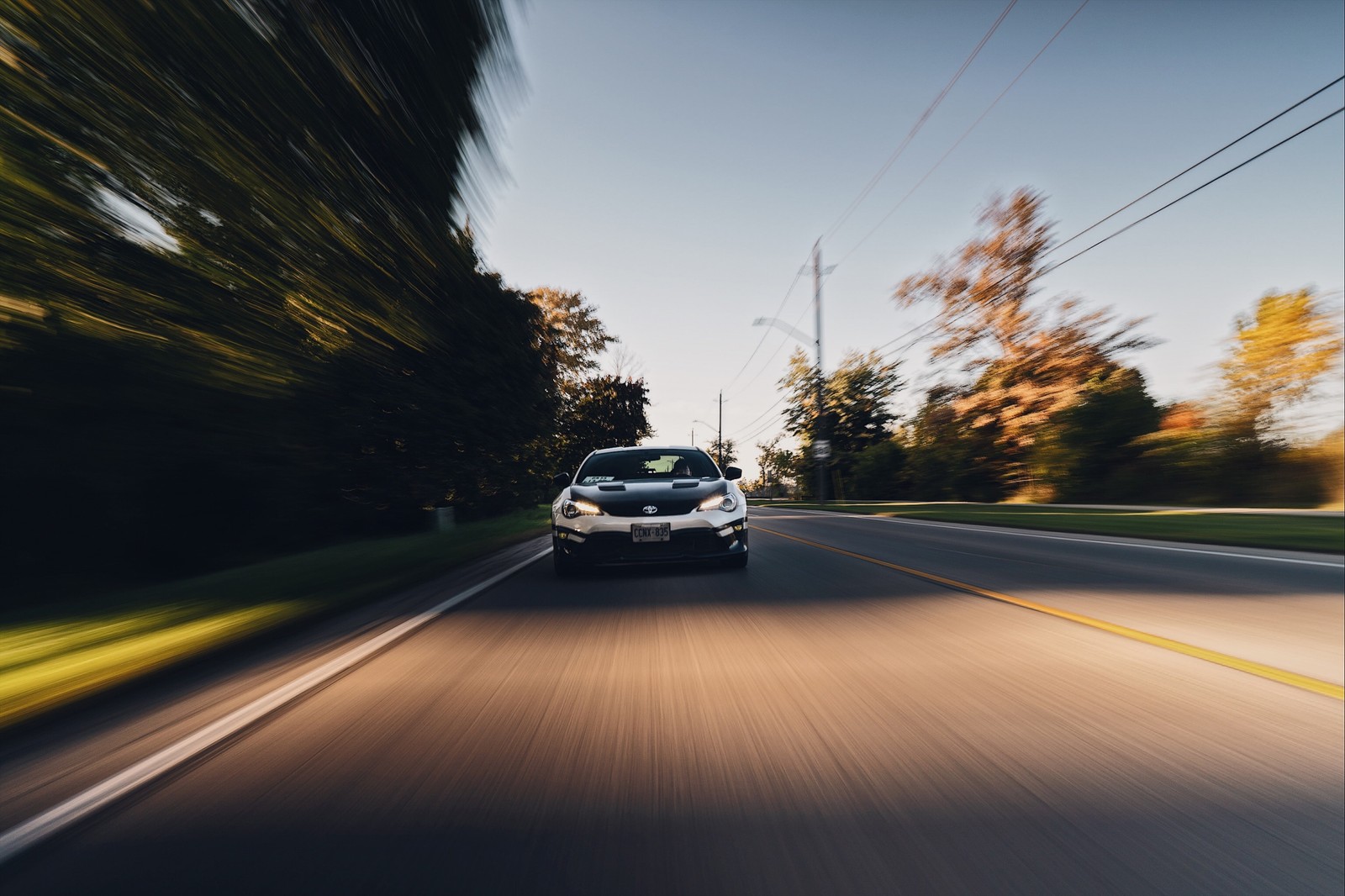 Verschwommenes foto eines autos, das die straße entlang fährt (straße, autobahn, asphalt, spur, fahrzeugaußenbereich)