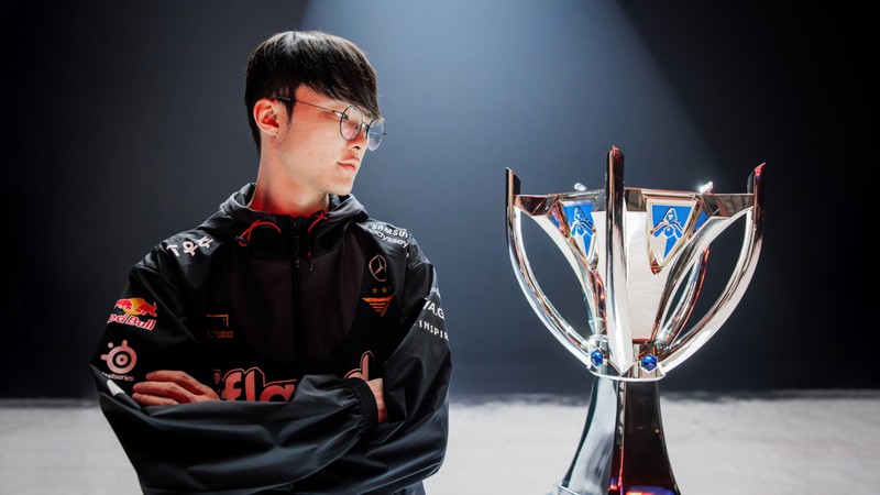 Крупный план человека, стоящего рядом с трофеем (фейкер, faker, league of legends, видеоигра, lol)