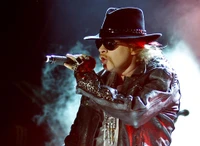 Axl Rose führt leidenschaftlich während eines Konzerts auf und verkörpert die Energie der Rockmusik mit seinem charakteristischen Stil.