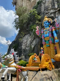 Majestic Hindu Temple Sculpture Featuring a Blue Deity and Decorative Chariot with Horses.