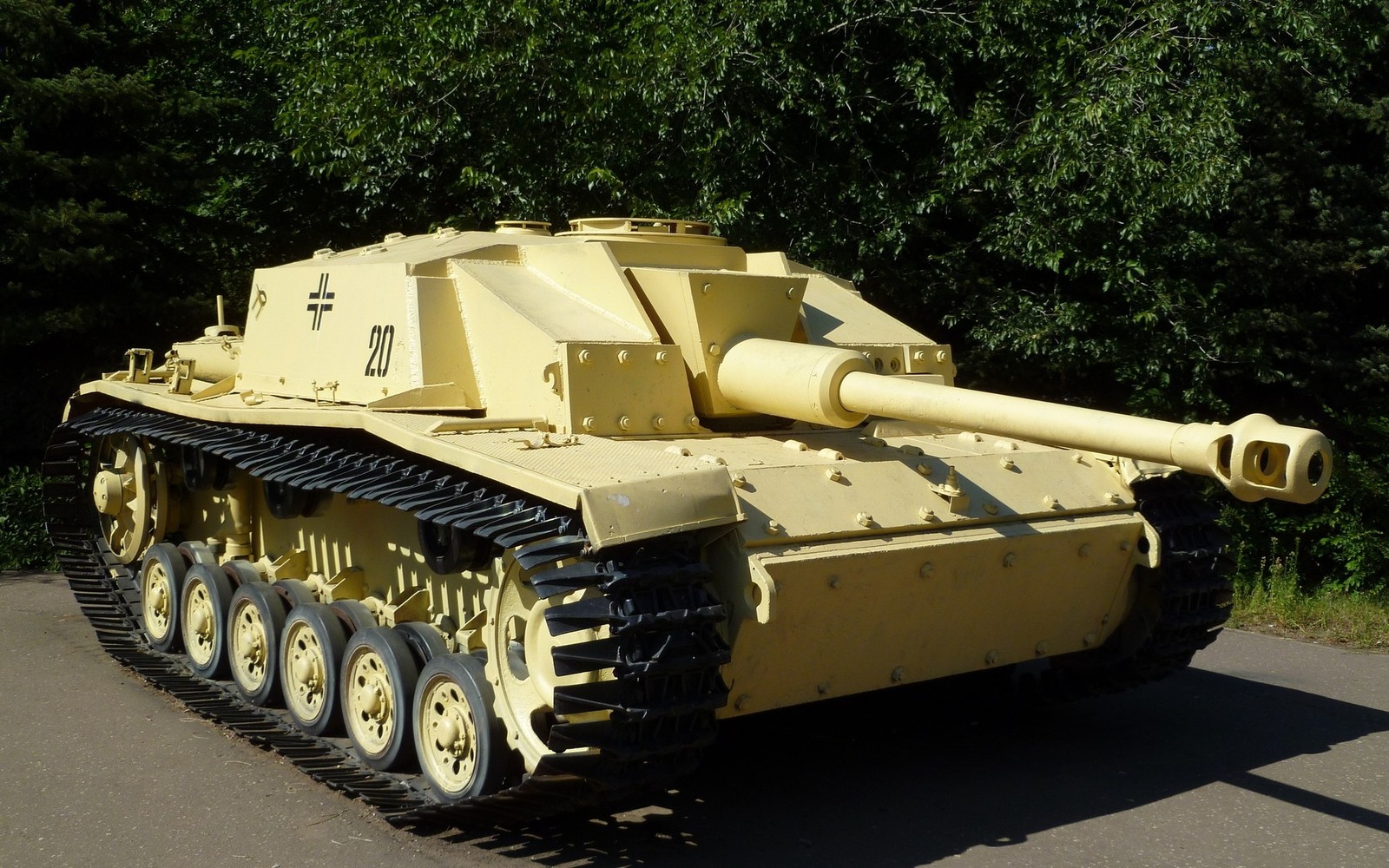 Un char jaune est garé sur le bord de la route (char, tourelle, voiture blindée, artillerie automotrice, véhicule à moteur)