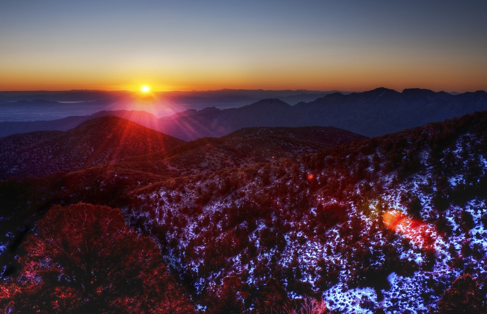 A view of a mountain with a sun setting over the mountains (desert, sunset, mountain, sunrise, ridge)