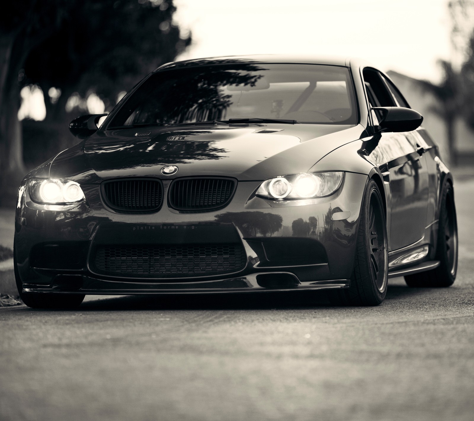 Un primer plano de una foto en blanco y negro de un coche (negro, coche, luces)