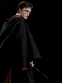 Daniel Radcliffe als Harry Potter, der einen Zauberstab in einer dramatischen Pose hält.