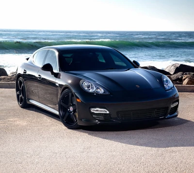 Eleganter schwarzer Porsche Panamera am Ozeanstrand