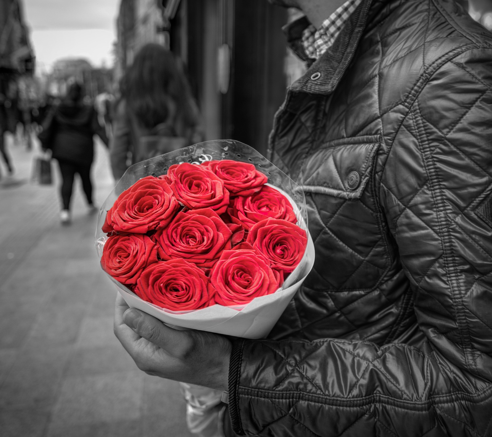 Um homem segurando um buquê de rosas vermelhas na mão (preto, azul, nuvem, flor, vermelho)