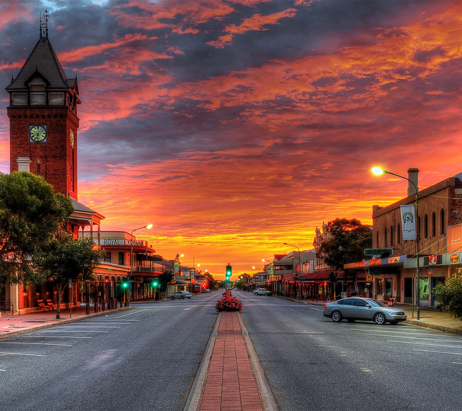 Pôr do sol sobre uma rua da cidade com uma torre do relógio e um céu vermelho (cidade, legal, estrada, por do sol)