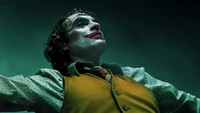 Joaquin Phoenix as the Joker, exuding chaos and intensity in a dramatic pose.