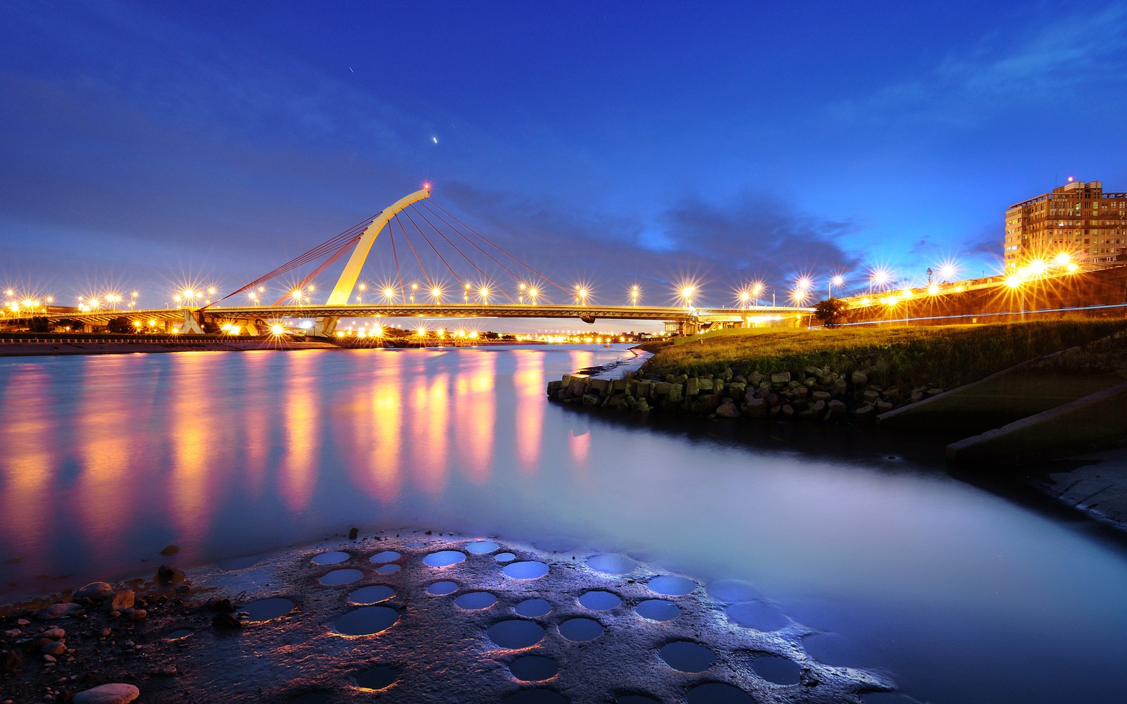 Panoramablick auf eine brücke über einen fluss bei nacht (brücke, wasser, reflexion, wahrzeichen, nacht)