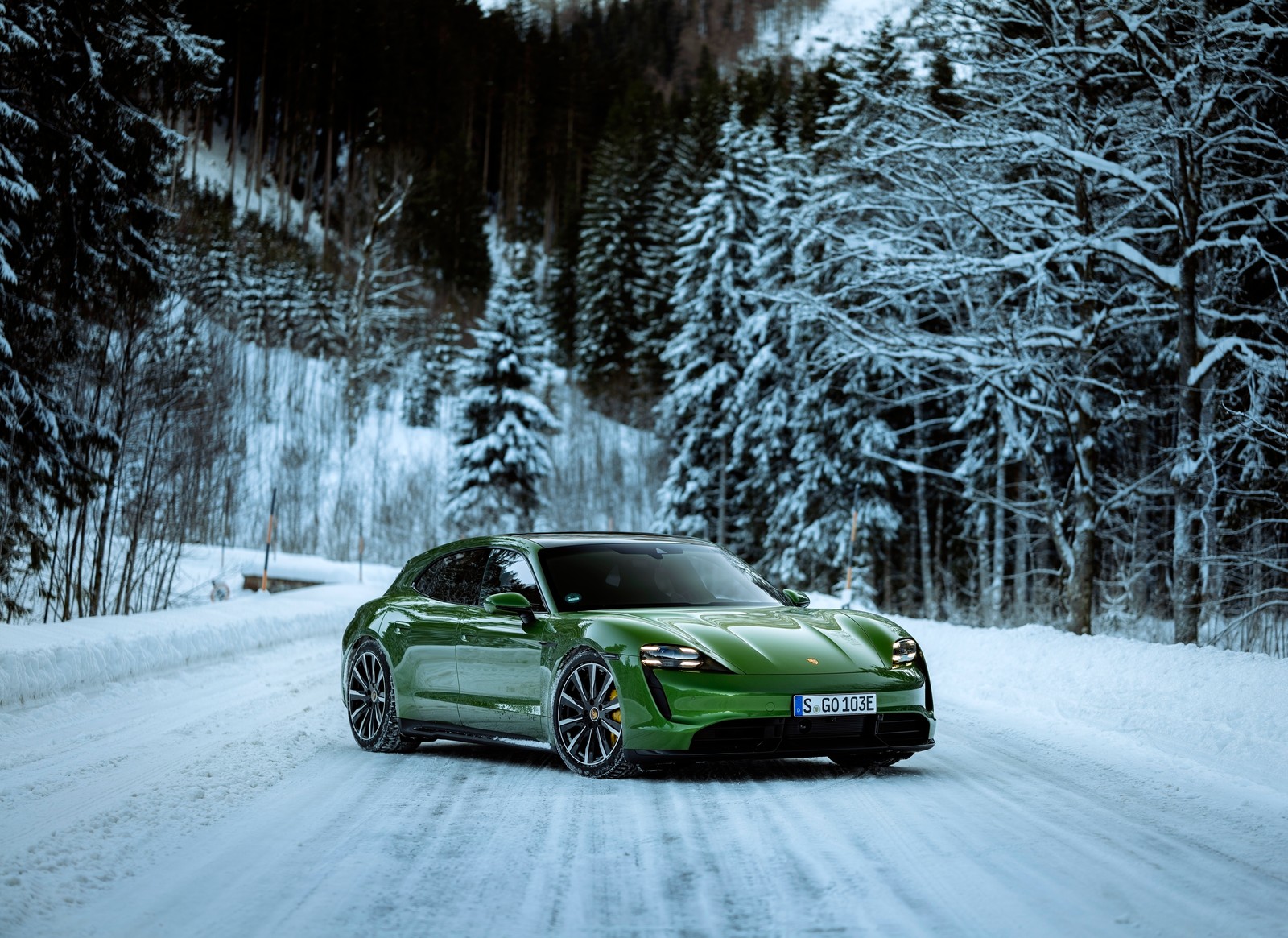 A close up of a green car driving on a snowy road (porsche taycan turbo s sport turismo, 2022, winter, snow covered, 5k)