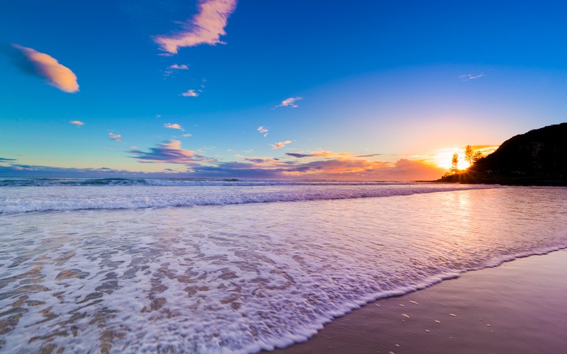 Вид на пляж с волнами и маяком вдали (burleigh heads, квинсленд, queensland, австралия, city of gold coast)