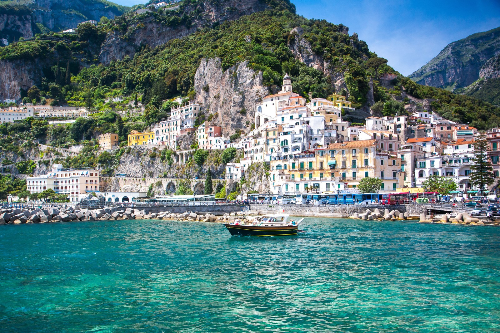 Uma vista de um barco na água perto de uma cidade (sorrento, positano, capri, costa, mar)