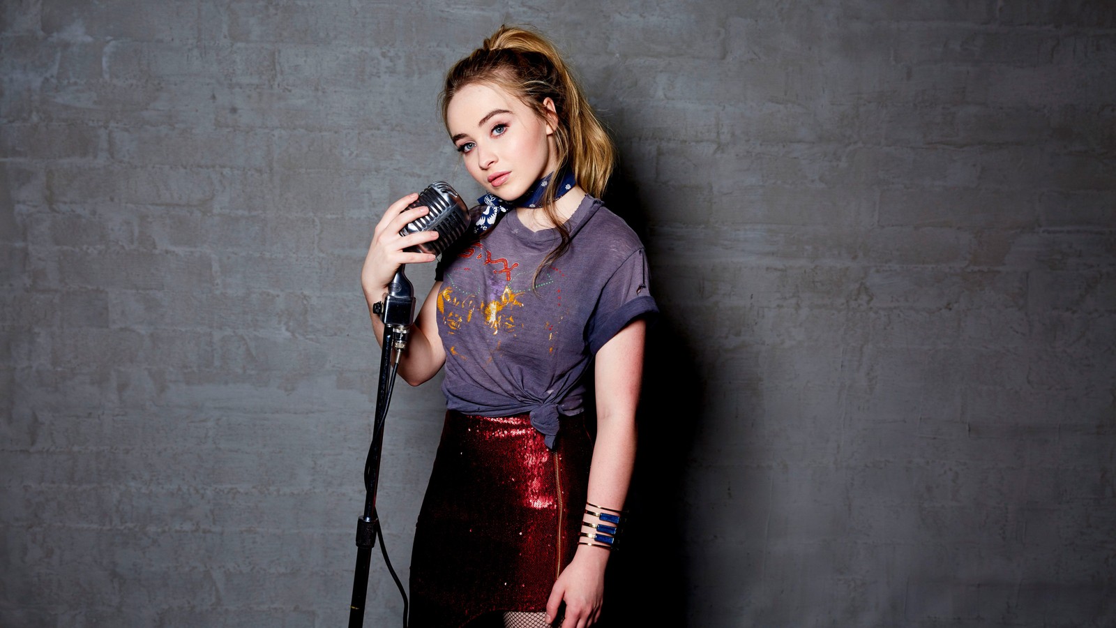 Mujer arafed en una falda roja sosteniendo un micrófono y posando (sabrina carpenter, cantante, celebridad, chicas, mujeres)