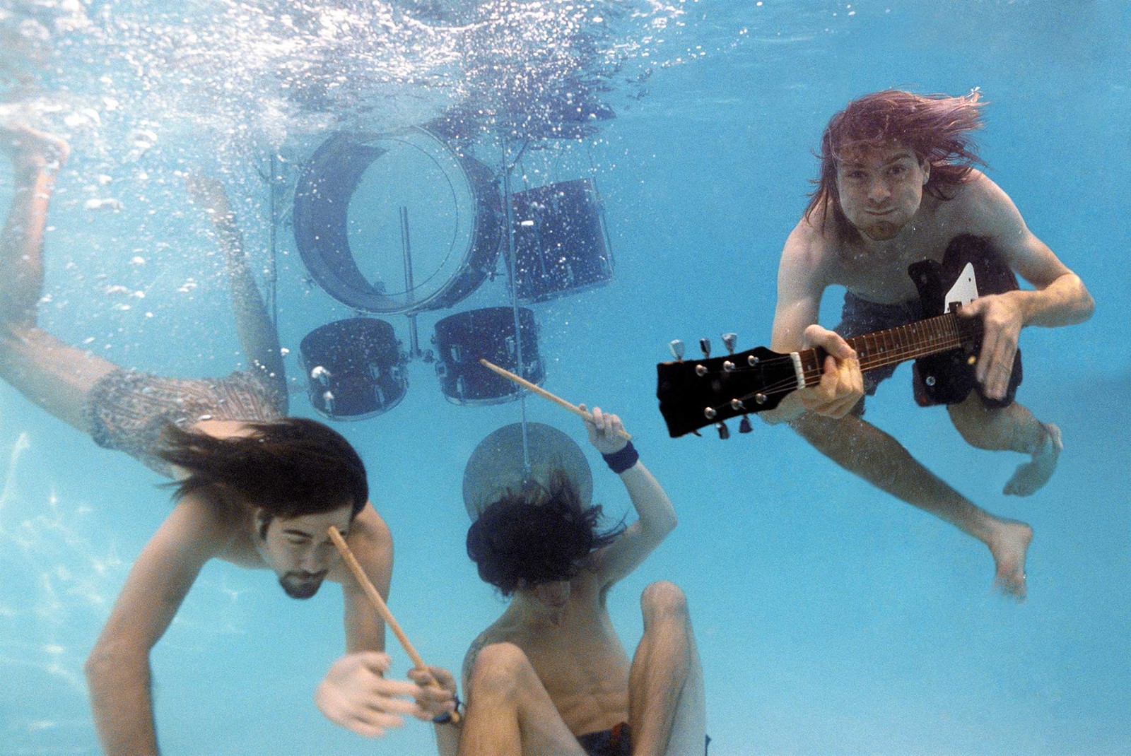 Três pessoas tocando música debaixo d'água em uma piscina (nirvana, grunge, água, diversão, subaquático)