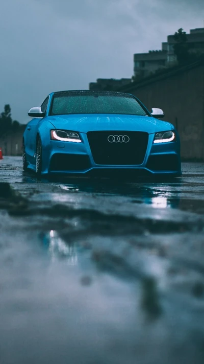 Audi azul elegante em uma rua chuvosa