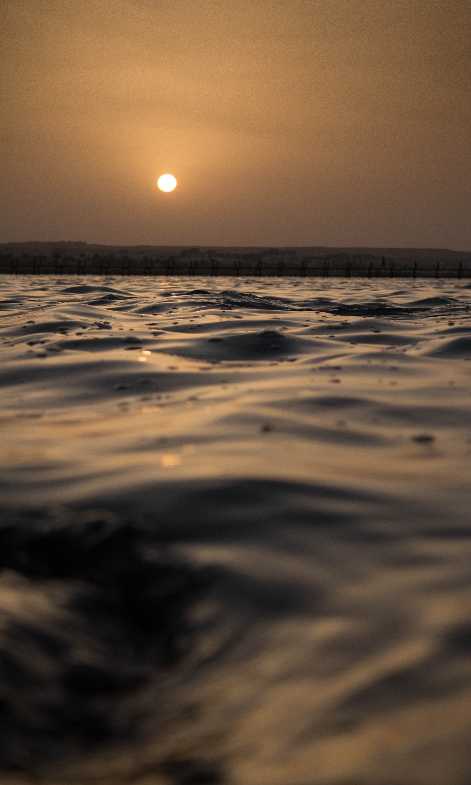 Vista arafed de um pôr do sol sobre o oceano com ondas (egito, egípcio, horizonte, oceano, mar vermelho)