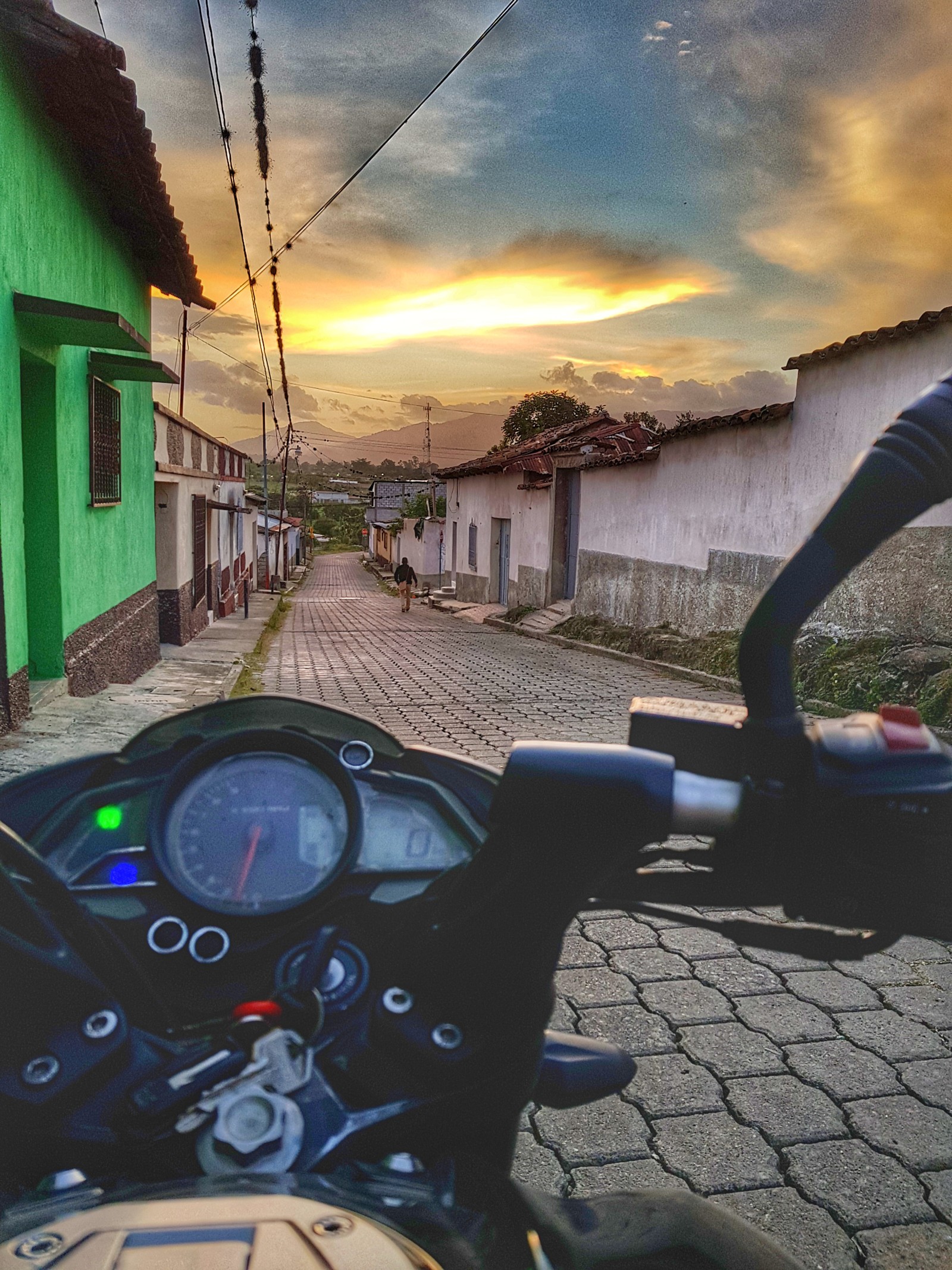 Vue floue d'une moto circulant dans une rue avec un coucher de soleil en arrière-plan (200, bajaj, beau, indien, moto)