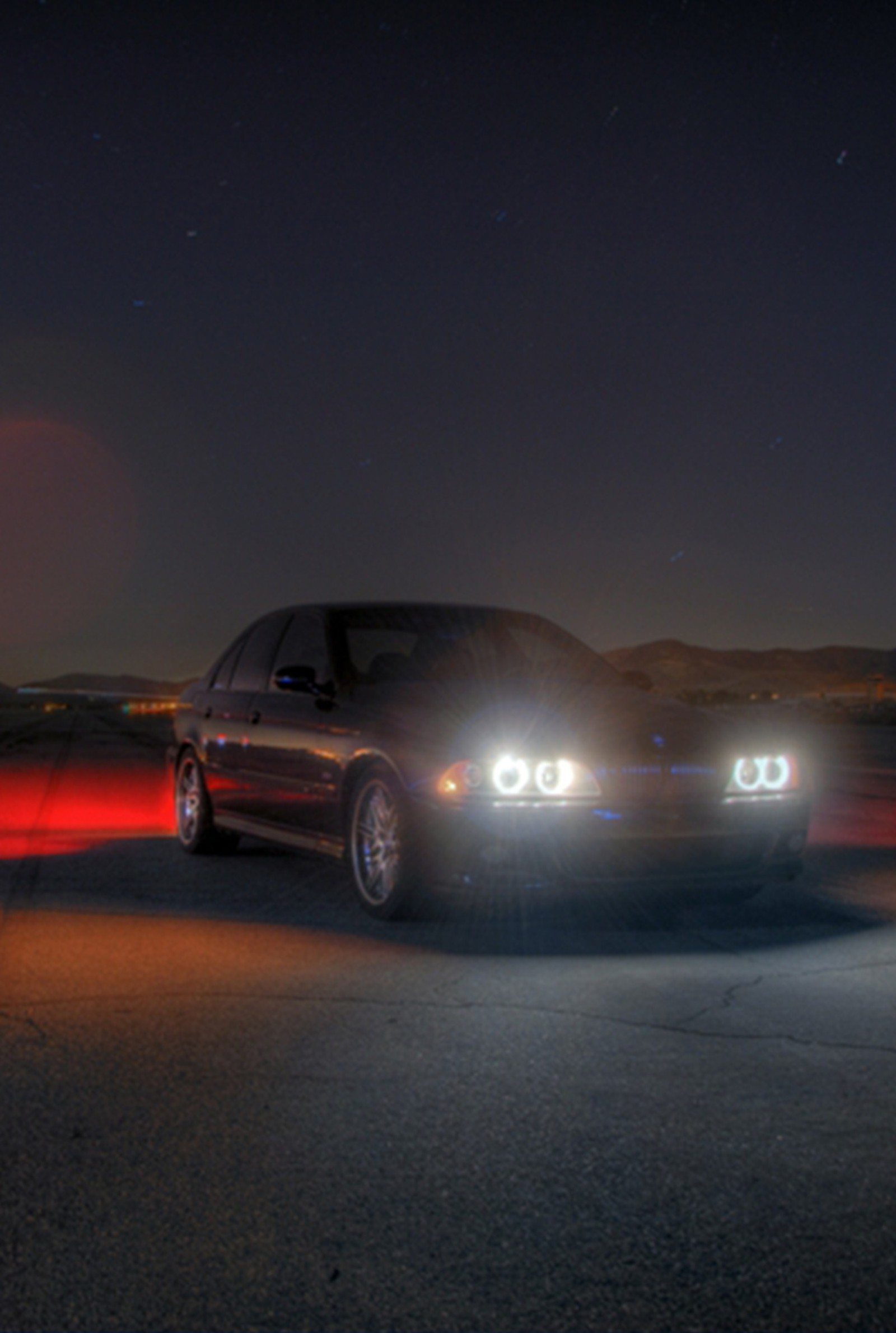 Há um carro dirigindo pela estrada à noite (bmw, carro, legal)