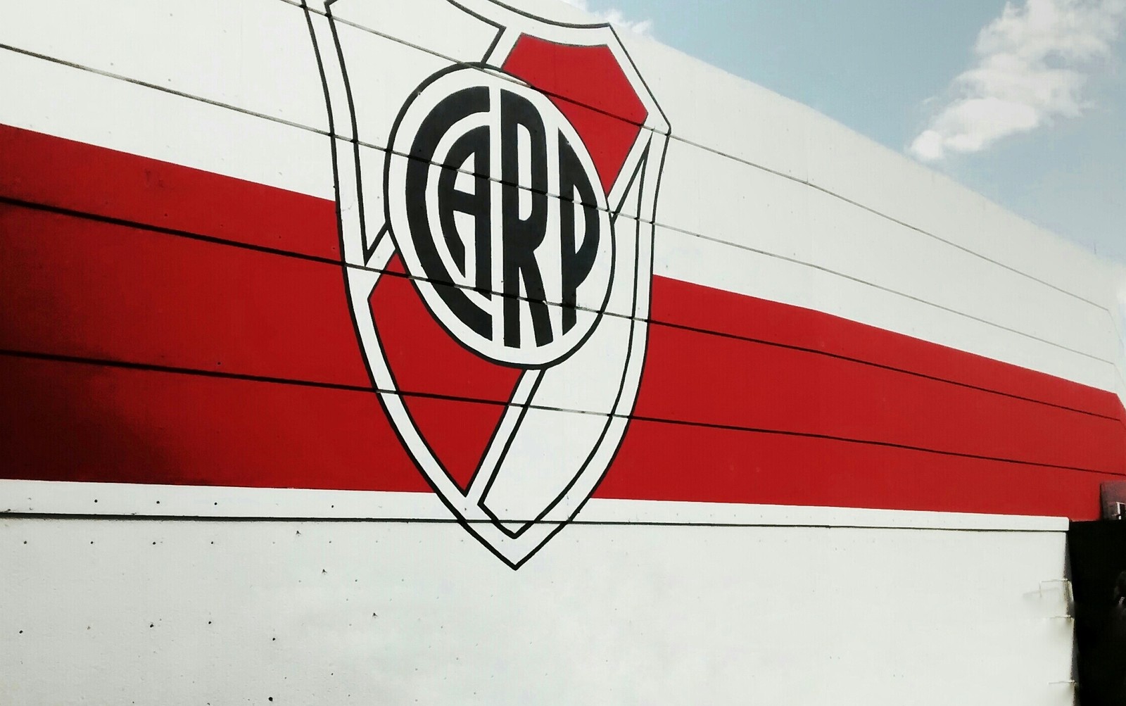 A close up of a red and white truck with a logo on it (blanco, carp, escudo, millonario, river)