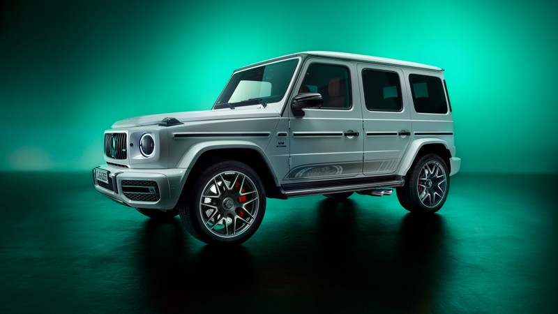 Серебристый внедорожник mercedes g-класса припаркован на зеленом фоне (мерседес амг g 63, mercedes amg g 63, 5k, g wagon, mercedes amg g class suv)