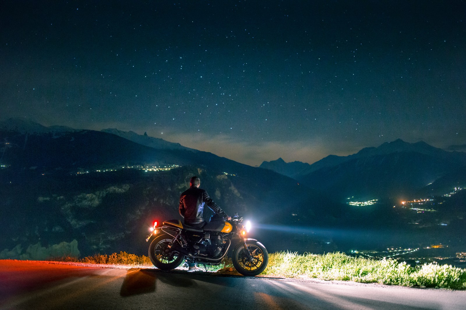 Motociclista em uma estrada à noite com montanhas ao fundo (motocicleta, noite, nuvem, cadeia de montanhas, espaço)