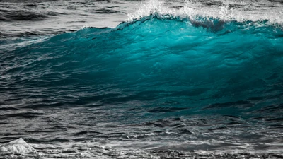 Brechende türkisfarbene Welle gegen das azurblaue Meer