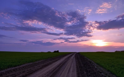 Aube sereine sur une route de prairie sous un ciel coloré