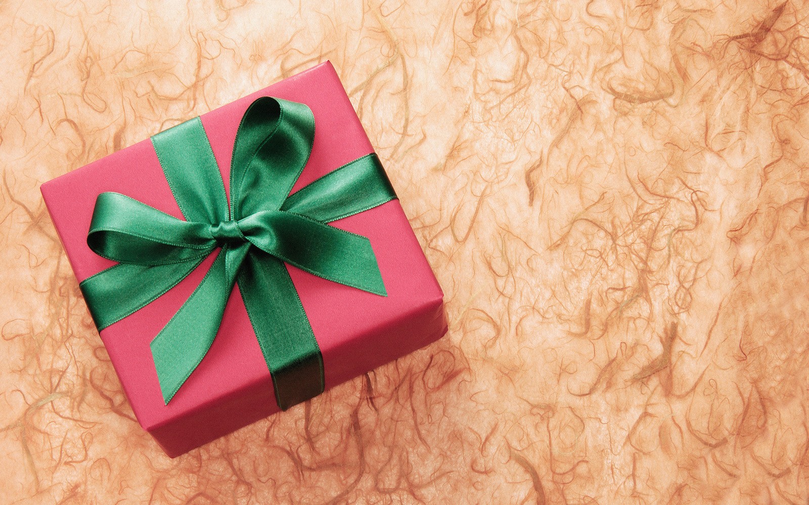 Un primer plano de una caja de regalo rosa con un lazo verde (presente, cinta, rosa, verde, envoltura de regalo)